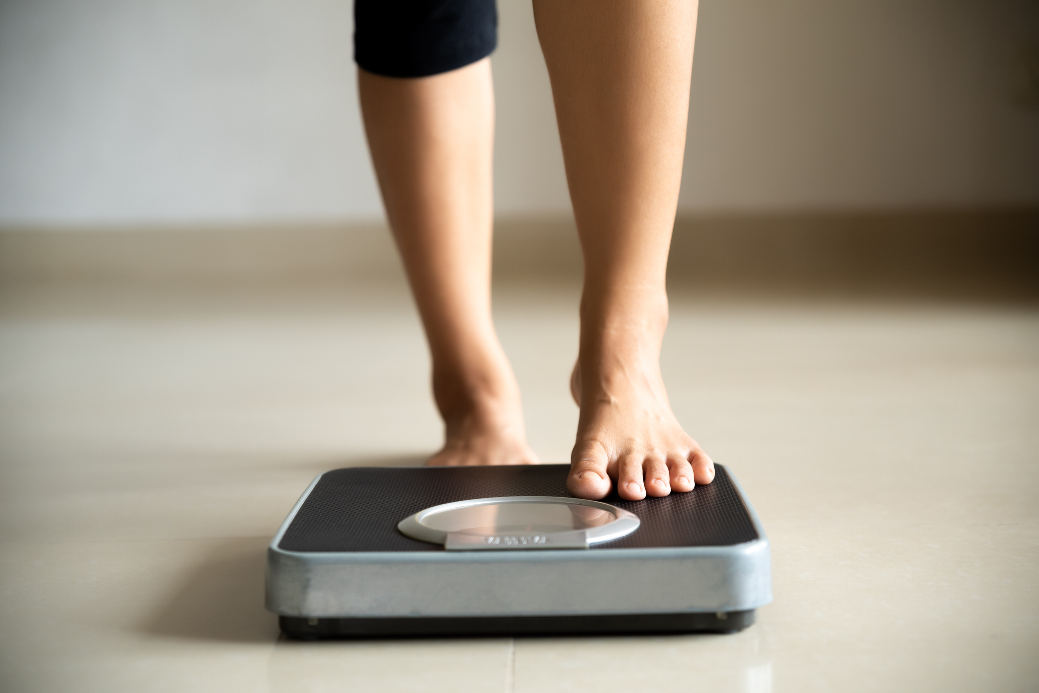 Female leg stepping on weigh scales. Healthy lifestyle, food and sport concept.